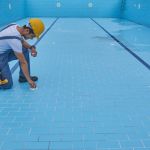 Repairman is repairing pool with equipment. Pool maintenance style.